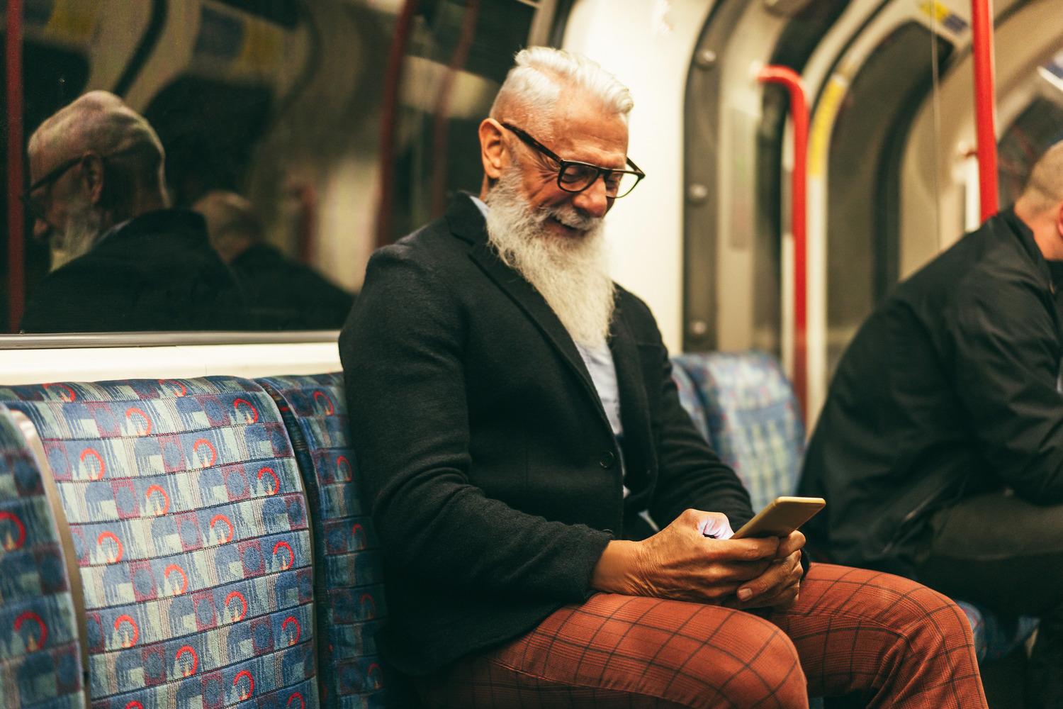Elderly man on subway looking at his social media. Depicting succesful home care agency marketing in action